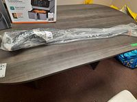 Full-length view of TaylorMade SIM2 Max driver in original plastic packaging on table