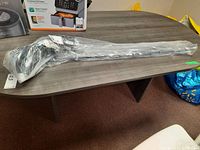 Full-length view of golf club in plastic wrap laid on table