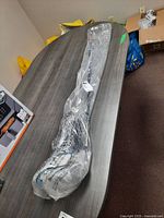 Overview of full club packaged in plastic sleeve on tabletop