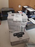 Four Logitech Brio 500 webcam boxes stacked