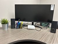 Front view showing LG monitor, pair of Bose speakers, pen holder, and power strip