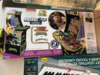 Full box front showing Arcade1Up logo, TMNT cabinet art and included games
