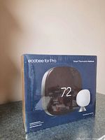 Front of sealed Ecobee Smart Thermostat Premium box showing '72' display and oval SmartSensor.