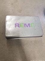 Closed metal container with Dremel logo on top showing condition and type of storage