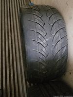 Photo of tire showing tread worn down with some internal structure visible, close up angle