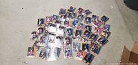 Photo of the entire lot of 59 basketball cards spread out on a floor surface showing variety of cards and players.