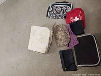 Photo showing six assorted small pouches including makeup carriers and other ladies items with zippers, laid out on a surface.