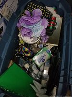 Medium tote filled with artificial flowers, ribbons, mask, and various small craft and household items.