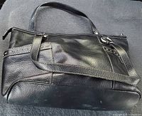 Front view of black Relic leather tote shoulder bag with metal studs and exterior pockets.