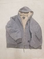 Full view of gray Walls hooded men's work jacket showing thick fabric and fleece lining inside.