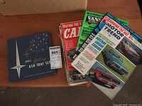 Cutler Galaxy ash tray set in its original box alongside a stack of vintage car magazines including Motor Trend and others.