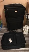 Two Samsonite luggage pieces on floor: one large rolling suitcase upright and one carry-on bag flat horizontal