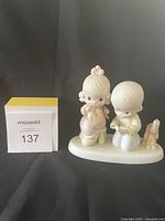 Front view of the Precious Moments figurine depicting a boy and girl with small dog on oval base.