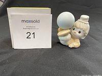 Precious Moments clown figurine seen from the front holding a light blue balloon, with seller's lot number card in background.