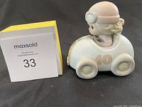 Side view of the figurine showing the child in the race car with the number 10 on the side.