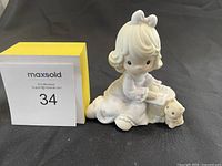 Front view of the Precious Moments figurine showing the girl reading with a small dog beside her.