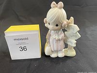 Front view of the Precious Moments figurine showing the girl standing by the signpost with Loving Caring Sharing text.