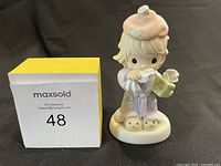 Front view of the Precious Moments Bless You figurine next to a MaxSold box with lot number 48.