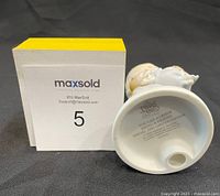 Photo of the figurine on its side showing the stamp and edition details on the base.