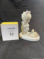Front view of the Precious Moments figurine showing a girl and a duck in a nest with eggs.