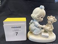 Image of Precious Moments figurine showing child and teddy bear with medical kit on white base.