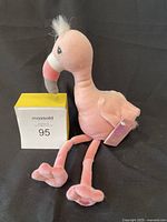 Pink flamingo plush toy photographed against dark background with MaxSold lot number 95 block.