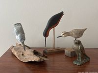 Five bird figurines including one mounted on driftwood base