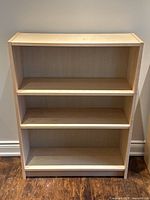 Front view of bookshelf showing three shelves and natural maple finish