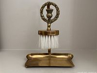 Front view of the full crumb catcher set showing brush in stand over tray