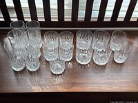 Overview of all 17 crystal glasses arranged on a wooden surface