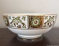 Side view profile showing alternating green and gold floral panels on white bone china