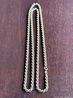 Full-length rope chain laid flat on wooden surface.