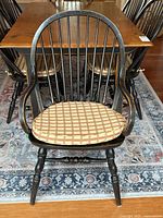Front view of one Windsor style spindle back armchair with cushion