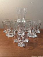 Set of 8 glass tumblers and 4 shot glasses with mushroom shape, embossed bee design visible
