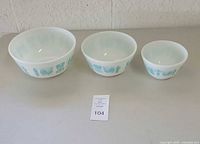 Three nesting Pyrex mixing bowls displayed side by side showing various sizes and the Butterprint design