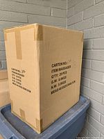 Cardboard box labeled with quantity and item description showing 20 massagers inside.