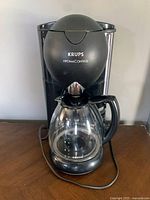 Full front view of the Krups Aroma Control coffee maker with glass carafe in place, showing overall condition and design.