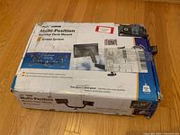Top view of original box with product image and details showing multi-position double monitor mount for desk use.