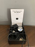 Wireless mini spy camera in its packaging with accessories and user manual.
