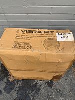 Cardboard box with Vibra Fit branding, product description and model information, price tag and condition sticker.