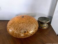 Large amber crackle glass shade and brass base shown from front angle on wooden surface