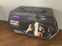 Photo of the Dream Vision virtual reality headset box, showing brand, VR compatibility logos, and image of the headset in use.