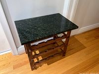 Front view of wood wine rack showing granite top and three-tier bottle storage shelves