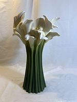 Front view of tall bonded marble calla lily cluster vase featuring white flowers and green stem base.