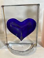 Glass block candle holder with recessed cobalt blue heart on clear glass block and platform base for votive candle