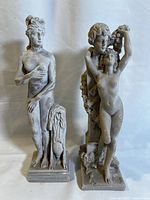 Two Greek-themed statuettes displayed side by side, showing full front view.