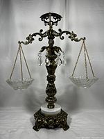 Full frontal view of the vintage scales showing ornate metalwork, marble base, glass bowls hanging on chains, and crystal accents.