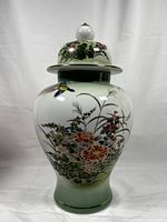 Full view of the porcelain ginger jar showing body and lid with floral and pheasant artwork, white to green glaze, and gold trim.