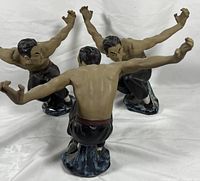 Photo showing all three Shaolin monk statues from a front angle displaying fighting poses and paint details.