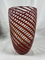 Front view of the vase showing clear glass with orange/red spiral threads tightly wrapped in a swirling pattern around the body.